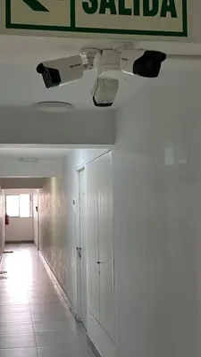 a hallway with white walls and a sign on the wall at HABITACIÓN EN EDIFICIO CENTRO COLONIAL- Cerca al centro histórico in Lima