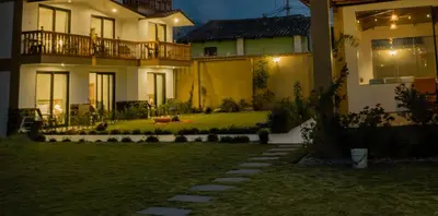 a house with a lawn in front of it at night at Tikawasi ollanta 2 incluye transporte o recojo a la estacion de tren in Ollantaytambo