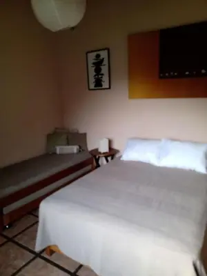 a bedroom with a white bed and a couch at Casa El Palto in Santa Eulalia