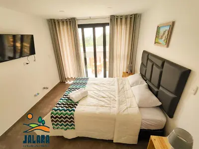 a bedroom with a large bed and a large window at Jalara hotel Boutique Lunahuaná in Lunahuaná