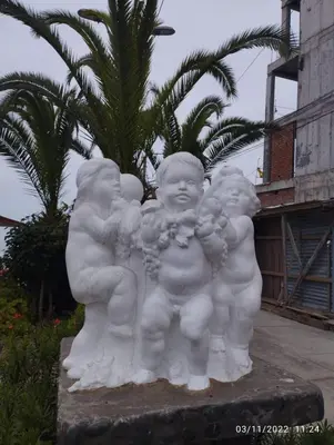 a white statue of three children holding flowers at Minidepartamento en San Bartolo - VISTA AL MAR in San Bartolo