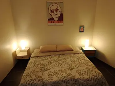 a bedroom with a bed with two nightstands and two lamps at Casa Nuestra Peru in Lima