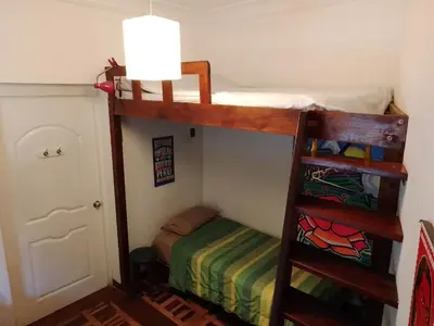 a bunk bed in a room with a bed in a room at Casa Nuestra Peru in Lima