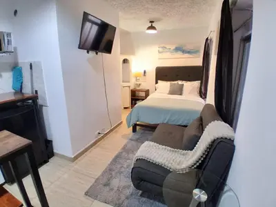 a bedroom with a bed and a couch and a tv at Centric, private, petfriendly apartments in Miraflores in Lima
