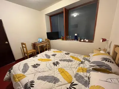 a bedroom with a bed with a quilt on it at The Sleepy Mouse in Cusco