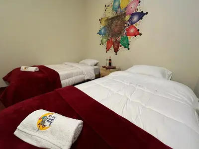 a hotel room with two beds and a towel at The Sleepy Mouse in Cusco