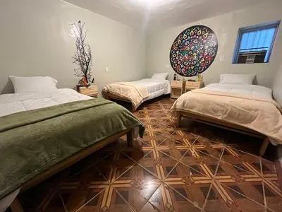 a room with two beds and a mirror on the wall at The Sleepy Mouse in Cusco