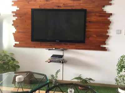 a flat screen tv hanging on a wall at Precioso cuarto dentro de un apartamento centrico compartido in Lima