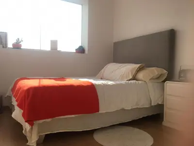 a bedroom with a bed with a red and white blanket at Precioso cuarto dentro de un apartamento centrico compartido in Lima