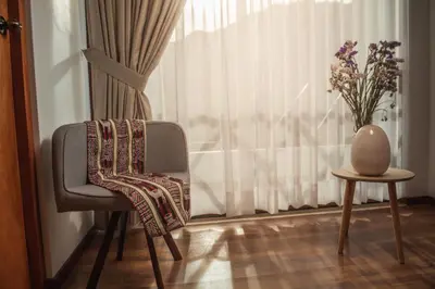 a chair and a vase sitting next to a window at Florez de la Villa in Huaran