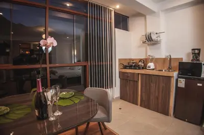 a kitchen with a wooden table and a dining room at Florez de la Villa in Huaran