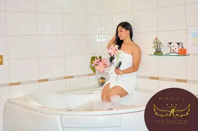 a woman sitting in a bath tub holding flowers at Hotel los angeles in Huaral