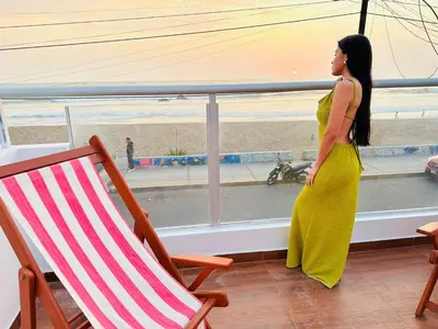 a woman looking out of a window at the beach at Casa de Playa Barranca in Barranca