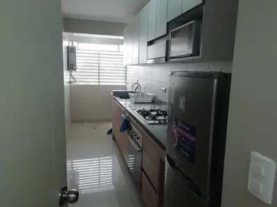 a kitchen with a stove and a refrigerator at Lindo y Espacioso Departamento muy cerca a Miraflores in Lima
