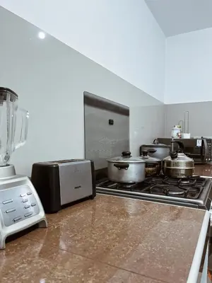 a kitchen with a stove with pots and pans at MH Apartments Ica in Ica