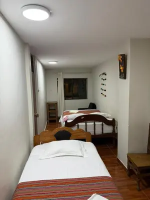 a bedroom with two beds in a room at Hospedaje Quillabamba in Santa Teresa