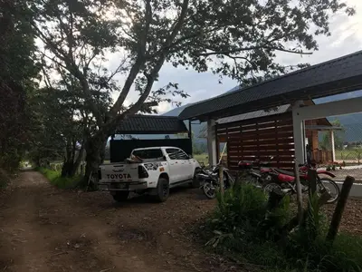 a white truck parked next to a building with motorcycles at Cabañas - Kobold Haus in Oxapampa