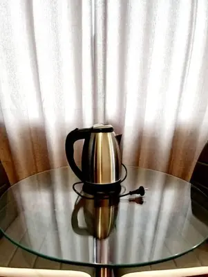 a tea kettle on a glass table in front of a curtain at Gorgeous Private Studio LIMA-Own Bathroom-Near Airport in Lima