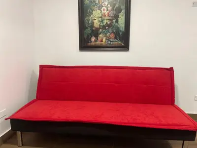a red bench in a room with a painting on the wall at (11) Nuevo y acogedor departamento en Miraflores. in Lima