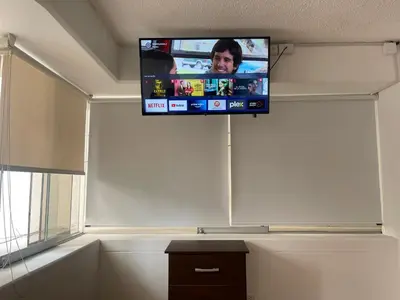 a flat screen tv on a wall in a room at (11) Nuevo y acogedor departamento en Miraflores. in Lima