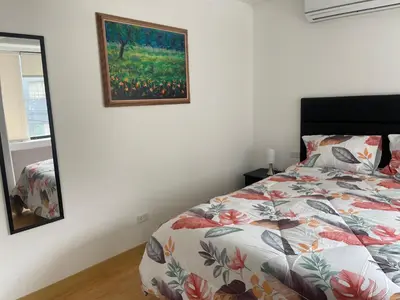 a bedroom with a bed and a painting on the wall at (12) Depto con inmejorable ubicación Miraflores in Lima