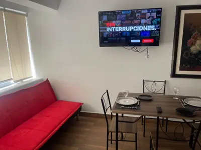 a living room with a red couch and a table at (12) Depto con inmejorable ubicación Miraflores in Lima