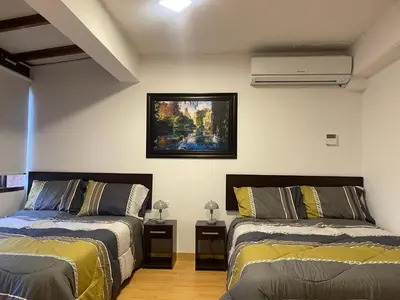 a bedroom with two beds and a painting on the wall at 19 Departamento en el centro de Miraflores in Lima