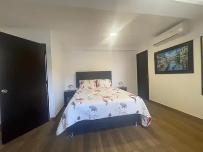 a bedroom with a bed with a floral bedspread at 15 Acogedor dpto de un ambiente en miraflores in Lima