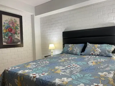 a bedroom with a bed with a blue comforter at 16 Dpto con inmejorable ubicación en Miraflores in Lima