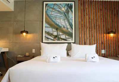 a large white bed with two folded towels on it at Black by Wynwood House in Lima