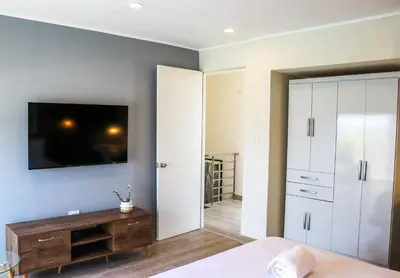 a bedroom with a bed and a tv on a wall at Black by Wynwood House in Lima