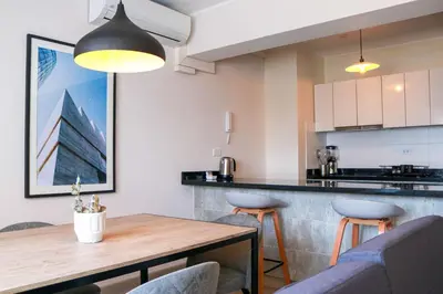 a kitchen and dining room with a wooden table and chairs at Black by Wynwood House in Lima