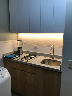 a kitchen with a sink and a stove and blue cabinets at Confortable and functional apartment in MIRAFLORES ! in Lima