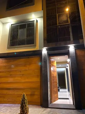 a house with a wooden garage door and a mirror at Hotel Alba in Ica