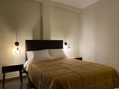 a bedroom with a large bed with two night stands at Hotel Alba in Ica