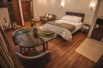 a bedroom with a bed and a table and a couch at Flores de la Villa in Huayoccare