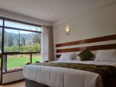 a bedroom with a large bed and a large window at Flores de la Villa in Huayoccare