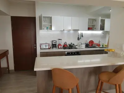 a kitchen with a counter and two chairs in it at Encantador apartamento en Miraflores in Lima