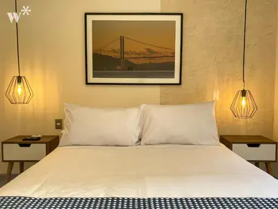 a bed with white pillows and a picture on the wall at Solar by Wynwood House in Lima