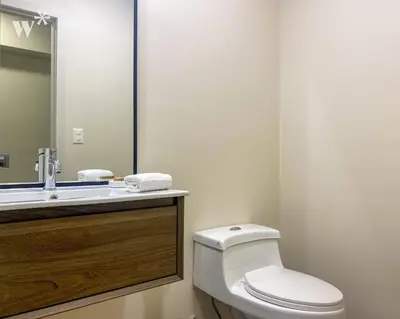 a bathroom with a toilet and a sink and a mirror at Solar by Wynwood House in Lima