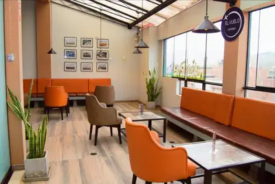 a restaurant with orange chairs and tables in a room at COSMOPOLITAN INN in Ventanilla