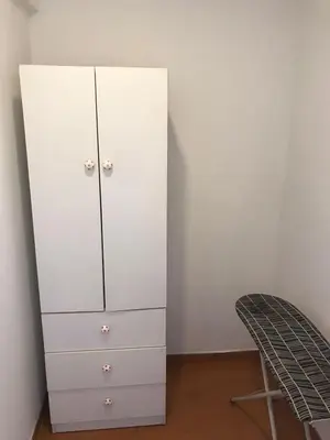 a white cabinet in a room with a chair at Hermoso Departamento en Guardia Civil - Chorrillos in Lima