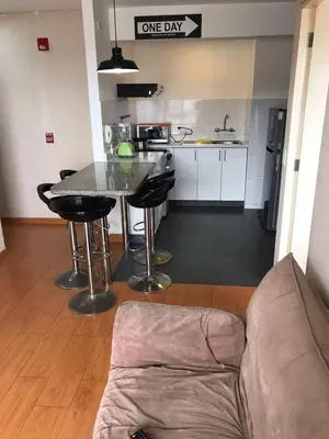 a kitchen with a table and a couch in a room at Hermoso Departamento en Guardia Civil - Chorrillos in Lima