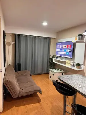 a living room with a couch and a table and a television at Hermoso Departamento en Guardia Civil - Chorrillos in Lima