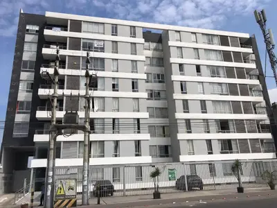 a large white apartment building on a street at Hermoso Departamento en Guardia Civil - Chorrillos in Lima
