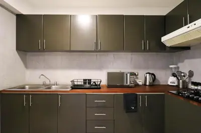 a kitchen with green cabinets and a sink and a microwave at San Martin 598 by Wynwood House in Lima