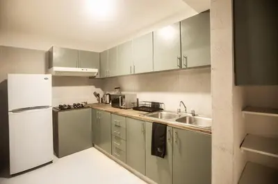 a kitchen with a white refrigerator and a sink at San Martin 598 by Wynwood House in Lima