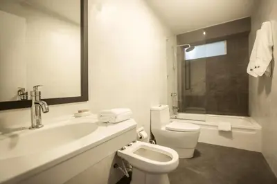 a white bathroom with a toilet and a sink at San Martin 598 by Wynwood House in Lima