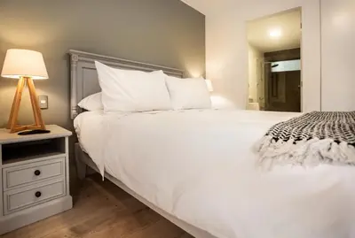 a bedroom with a large white bed and a lamp at San Martin 598 by Wynwood House in Lima