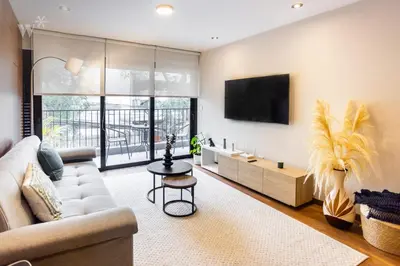a living room with a couch and a tv at Alcanfores 1262 by Wynwood House in Lima